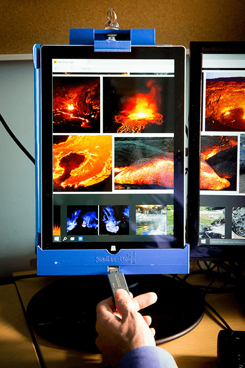 Photo of docked Surface Pro with two other table top screens