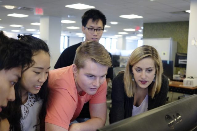 Cambridge, Massachusetts Garage interns working together around a desktop computer