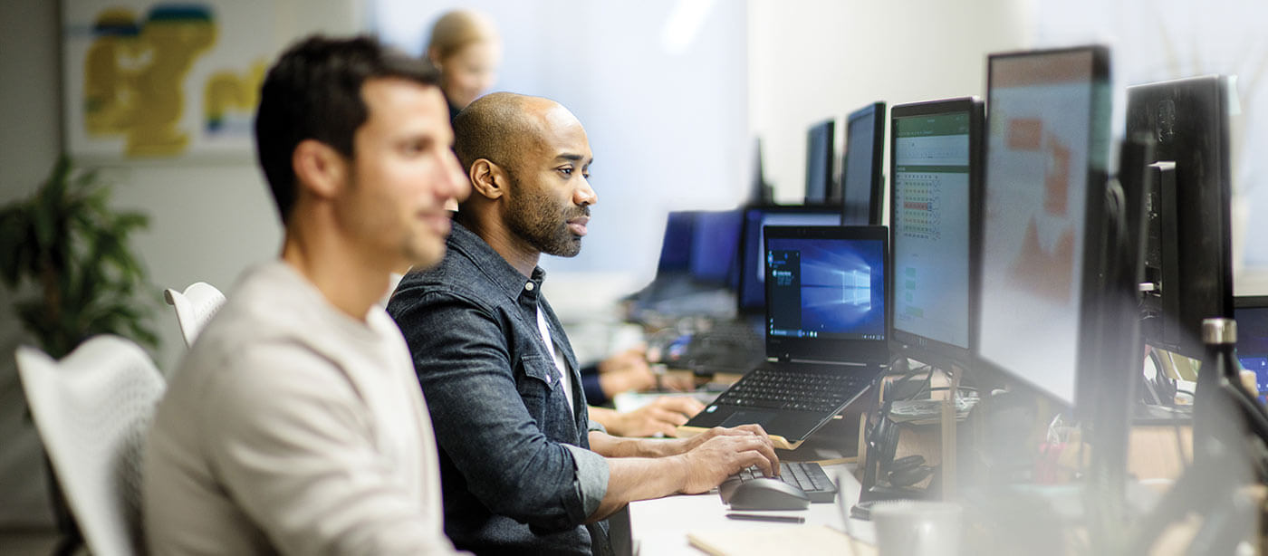 two men working side by side on computers