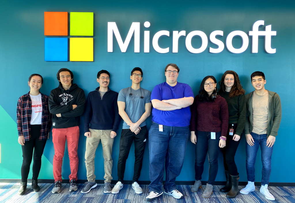 MIT externs standing in front of Microsoft sign